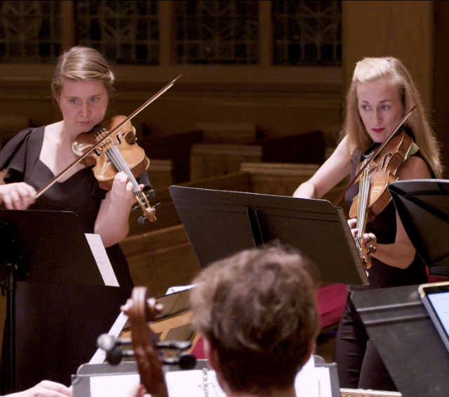violinists playing Baroque music in concert